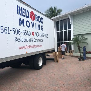 Red Box Moving crew packing and loading a truck on a real job site