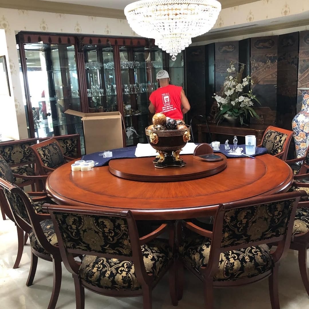 Red Box Moving crew member packing a china cabinet in a Fort Lauderdale home