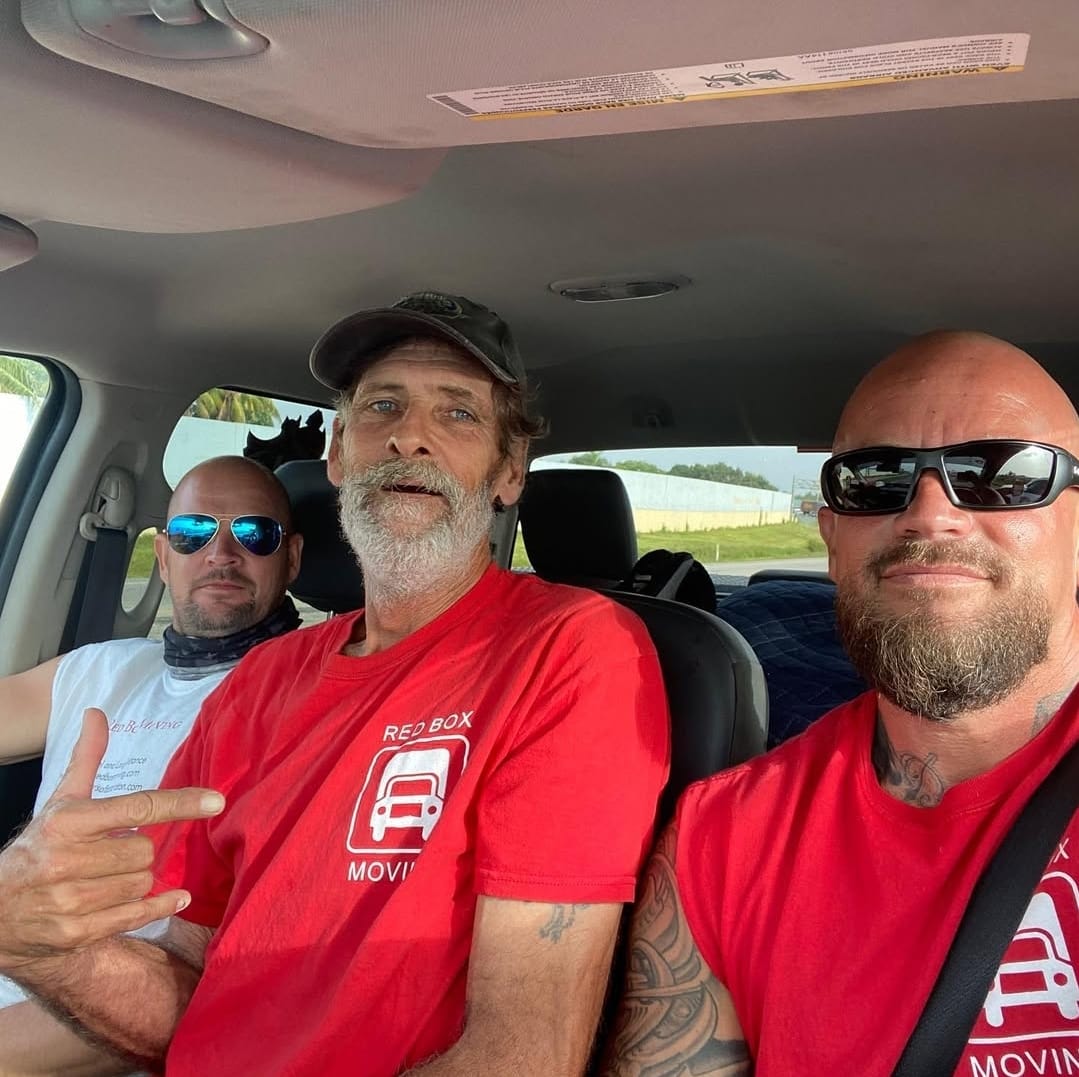 Red Box Moving crew in the truck cab heading to a job