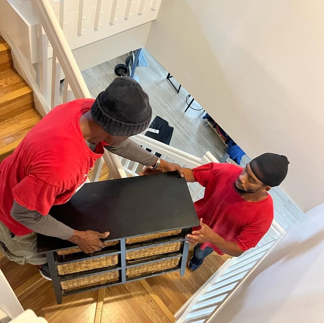 Red Box Moving crew carrying furniture down stairs in a Delray Beach home