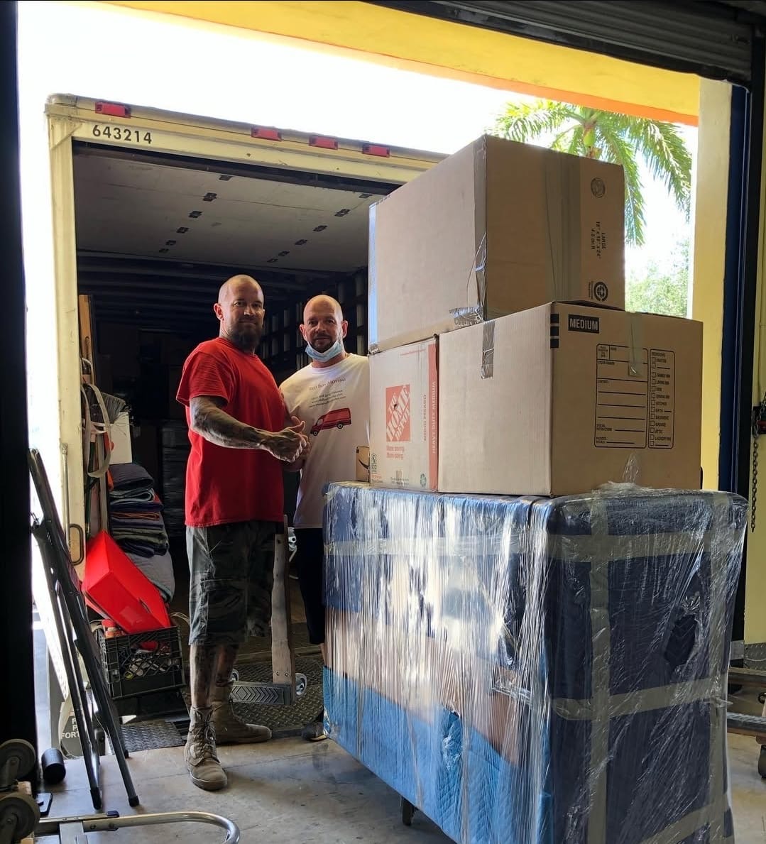 Red Box Moving crew loading a truck with wrapped items in Pembroke Pines