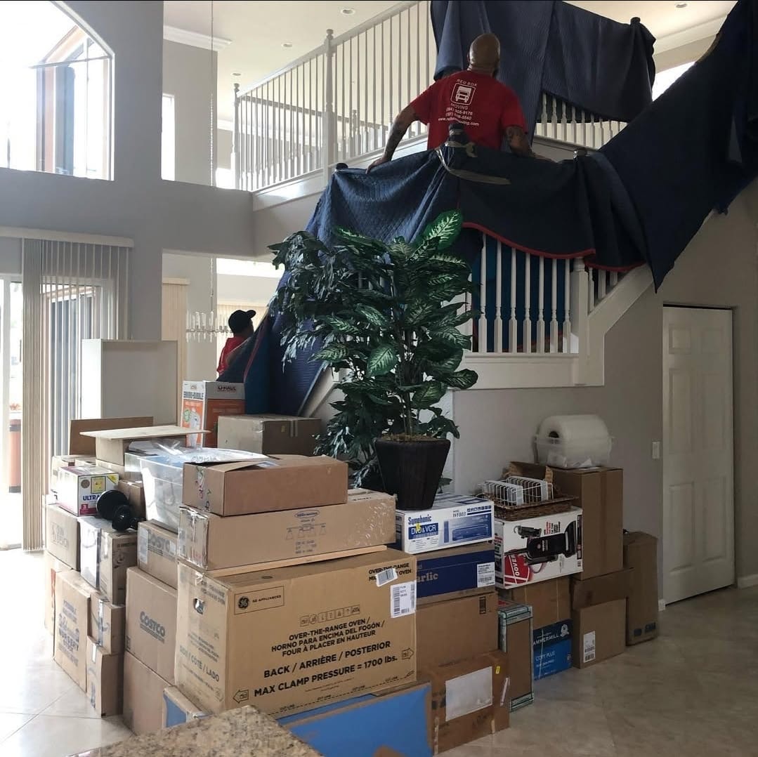 Red Box Moving crew lowering furniture from a second floor
